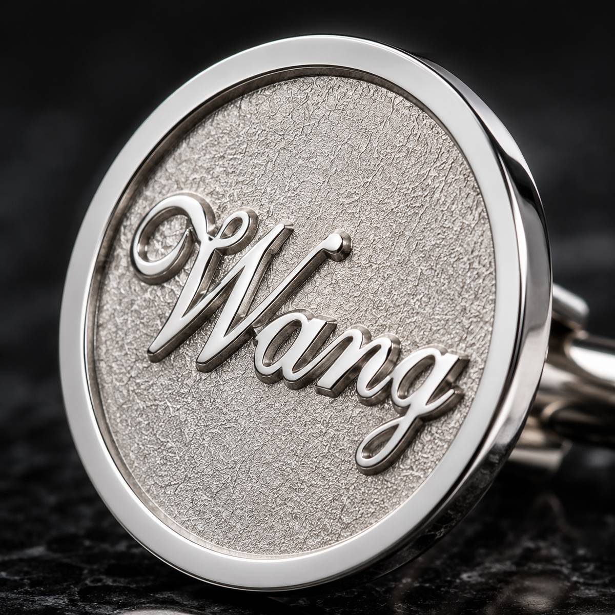 Close-up of laser engraved logo on round metal cufflink